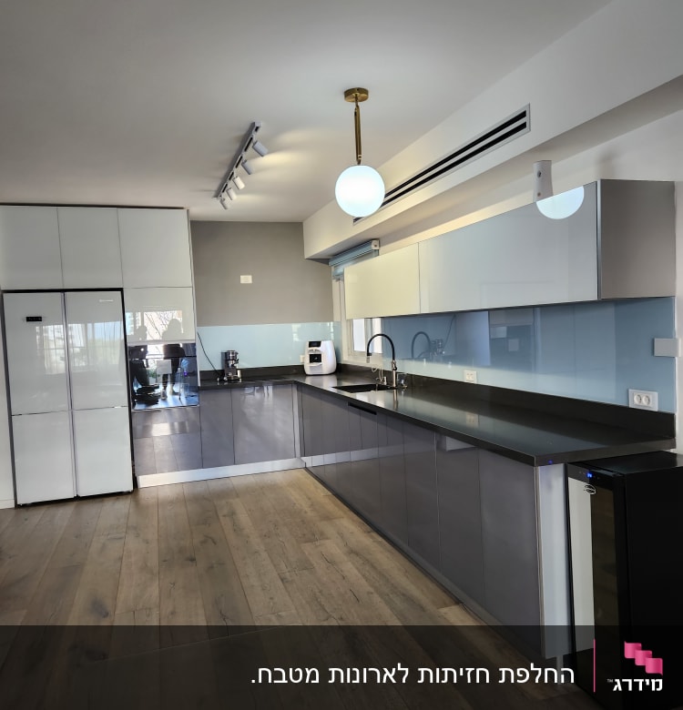 מטבח מודרני עם ארונות אפורים ומשטח עבודה כהה